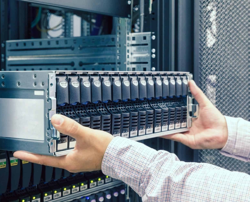 IT worker pulling out large server rack