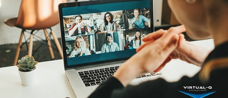 woman uses laptop to video conference with six coworkers