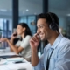 Image of a person in an IT center, talking to somebody over headset.